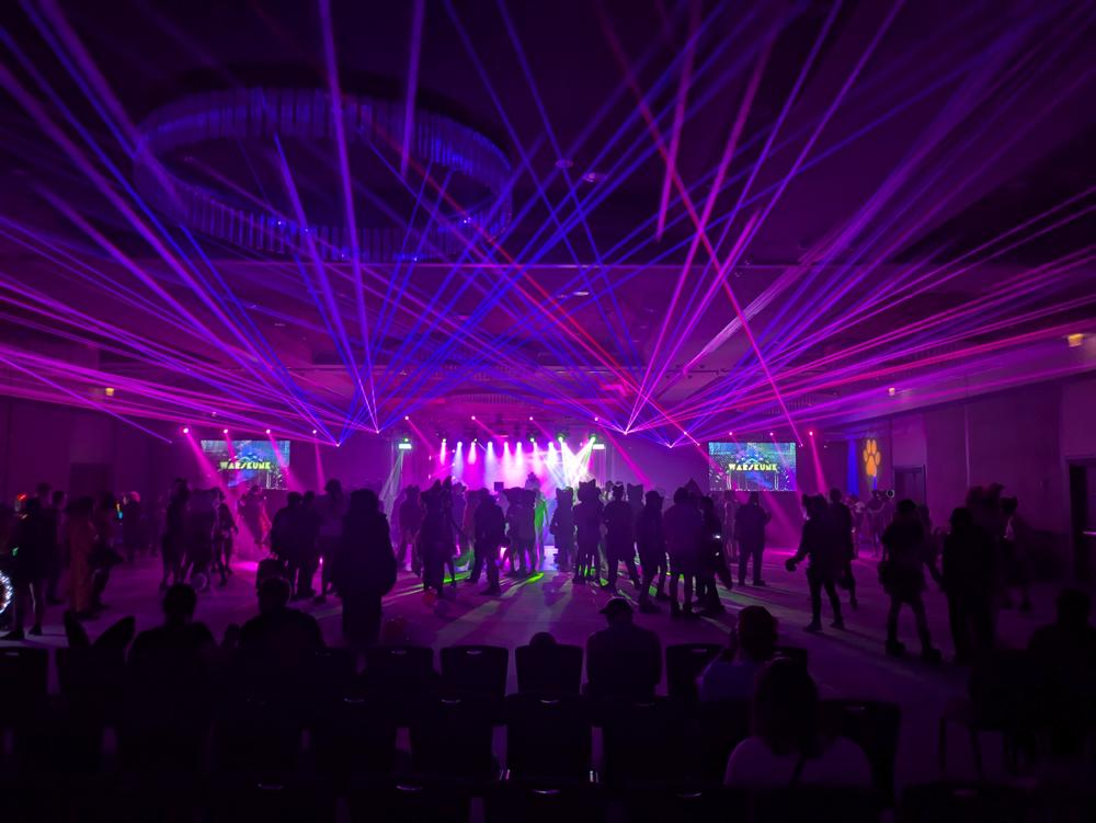 A rave in a dark room. There's lots of stage lights and lasers